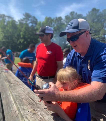 Police officer fishing with special needs child